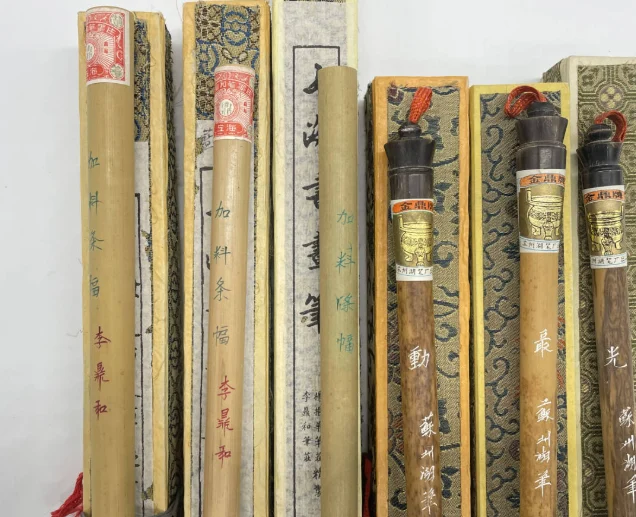 竹の筆管に「加料条幅 李鼎和」と書き入れられた筆（近年の復刻品）と、「金鼎牌」のラベルが巻かれた蘇州湖筆の筆