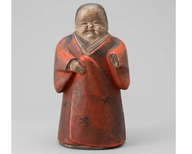 東京都世田谷区の旧家から出てきた江戸時代の嵯峨人形 — 朱の衣に墨描きの丸文、胡粉の童顔、両手を胸もとに添えた木彫の立ち姿